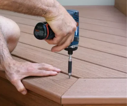 Hand holding drill while building a deck