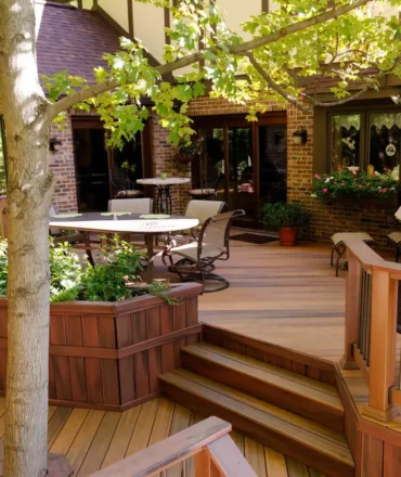 Composite Deck Ideas: Multi-level brown deck with large built-in planter next to stairs