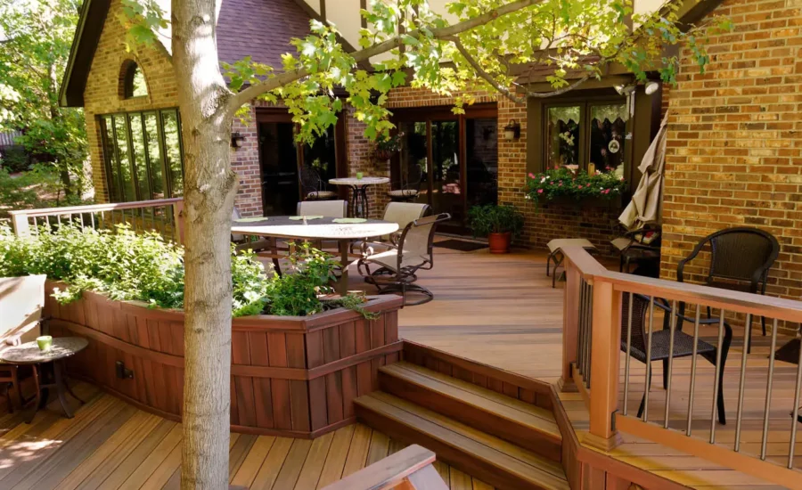 Composite Deck Ideas: Multi-level brown deck with large built-in planter next to stairs