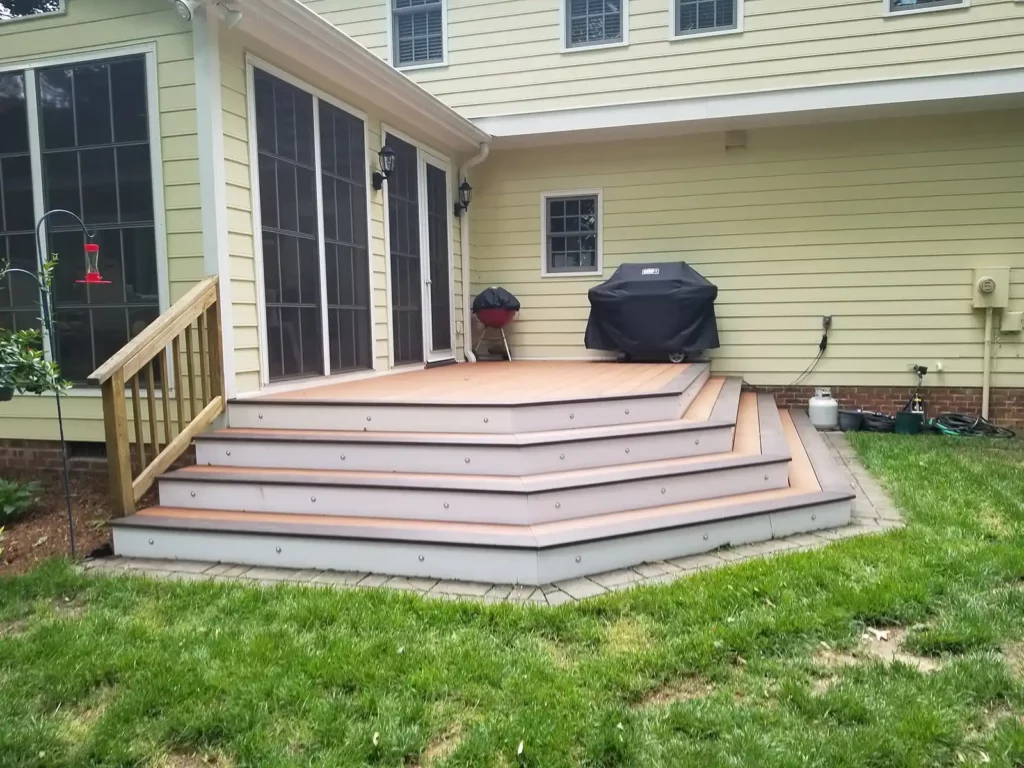 Angled shot of composite decking next to yellow house