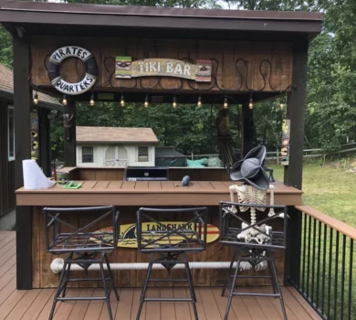 A tiki bar on a deck with a skeleton dressed as a pirate seated