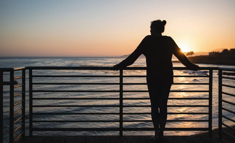 Woman leaning against a railing overlooking water