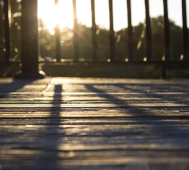 A weathered pressure treated wood deck with sunlight burst