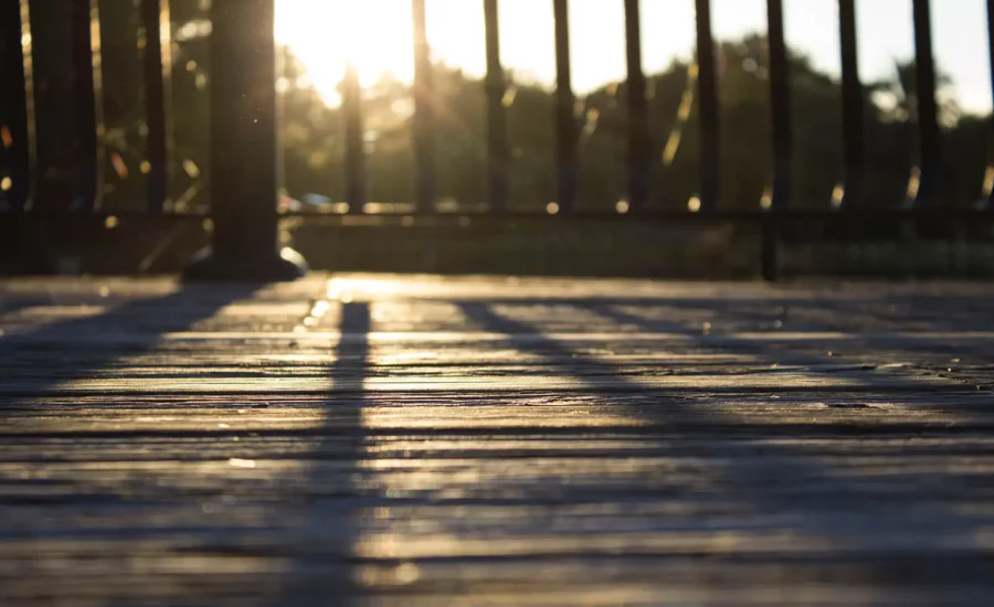 A weathered pressure treated wood deck with sunlight burst