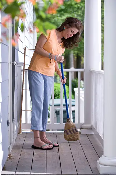 A woman sweeping her deck.