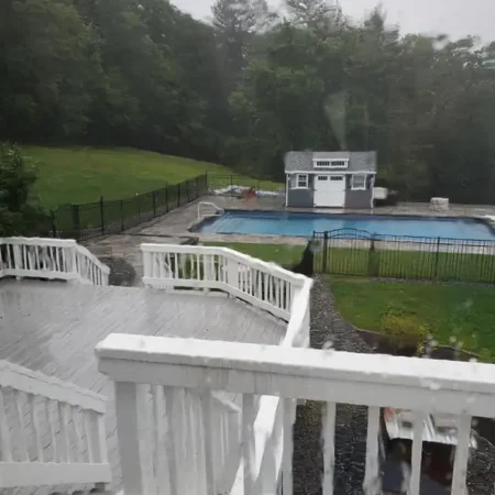 An old gray composite deck on a rainy day.