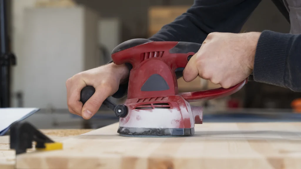 A man using a sanding device.