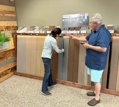 A man helps a woman shop for deck boards.